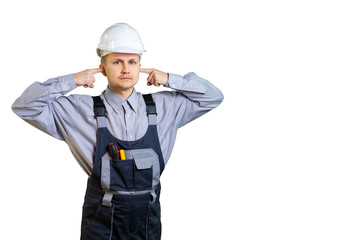 A young builder engineer puts his hands over his ears. He does not want to listen to advice on the repair and construction of buildings. Isolated