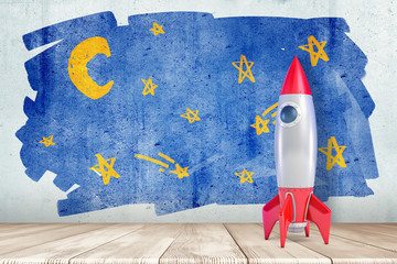 3d rendering of a toy space rocket standing at the wall with a children's drawing of a starry sky.