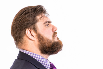 face profile portrait of a big handsome serious bearded business man in a dark suit, isolated on white