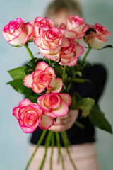 The bride holding a bouquet in front of him roses 