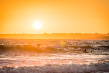 Fototapeta na wymiar Surfing in the sunset in Bretagne in France in the summer