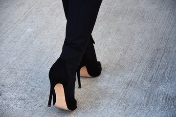 woman goes in black basilen high heels