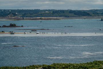People fishing shells by foot at low tide in Brittany