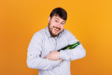 happy man with a bottle on his hands looks into the camera, beer love concept