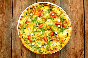 Italian pizza on a wooden background close up, top view