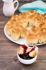 Pull apart monkey bread with black currant jam in a plate on a wooden plate