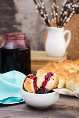 Still life with pieces of monkey bread and berries jam on a wooden table. Rustic style