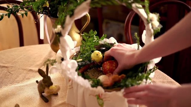 Hand arranging easter basket traditionally brought to church to be blessed on Holy Saturday, super slow motion