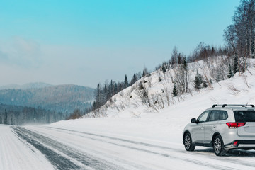 Suv car stay on roadside of winter road. Family trip to ski resort concept. Winter or spring holidays adventure. car on winter snowy road.