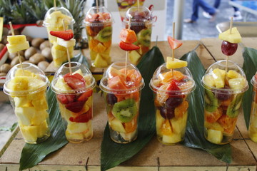 Bicchieri con frutta fresca in vendita a mercato