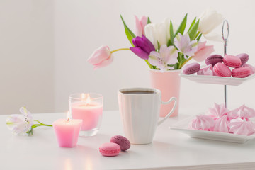 Tulips in vase and cup of coffee with dessert on white background. Concept woman's or mother's day
