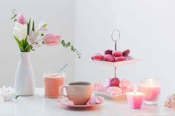 Fototapeta na wymiar Tulips in vase and cup of coffee with dessert on white background. Concept woman's or mother's day