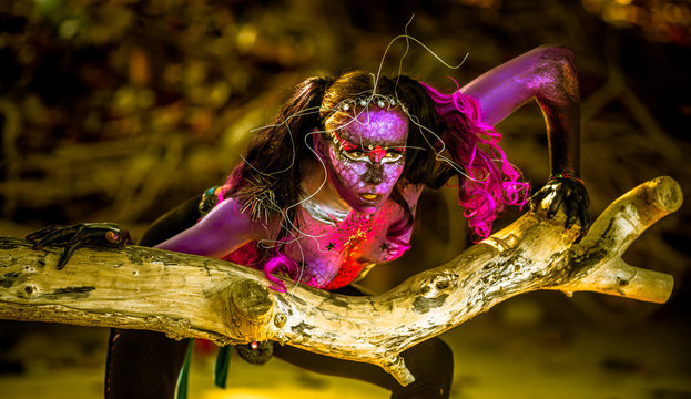 Woman in bodypaint playing on the Mangrove beach