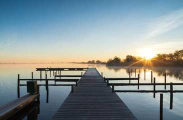 Tranquil sunrise at a jetty at the Leekstermeer, Holland.