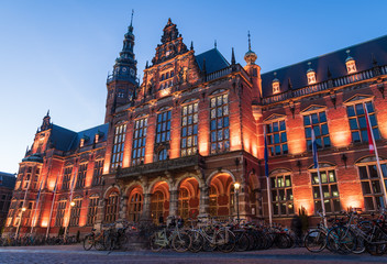 Academy building of the University of Groningen illuminated at night.