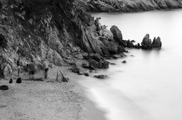 Landscape from a rocky shore. The rocks descend sharply to the shore there is a small strip of sand.