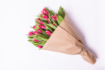 Bouquet of a pink tulips lying isolated on background white Kraft paper