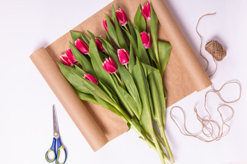 Preparation of Bouquet of tulips, wrapped in paper and decorated with ribbon