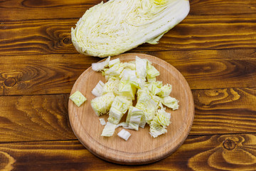 Chopped chinese cabbage on cutting board on wooden table