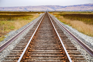 Fototapeta premium Railroad tracks across marshland, Alviso, San Jose, south San Francisco bay area, California
