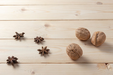 Walnuts, cinnamon and star anise on a wooden table.