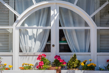 Old white wooden window frame with flowers