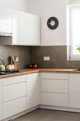 Minimal white kitchen interior with wooden countertop. Real photo