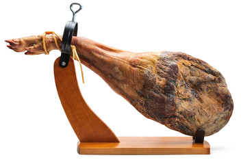 Whole leg of Spanish Iberian serrano ham in wooden support (jamoneror). Isolated on white background. - obrazy, fototapety, plakaty
