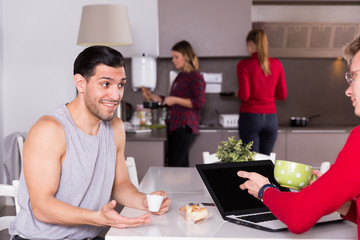 Man discussing with guy in kitchen of hostel