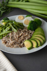 Salad bowl with quinoa and green vegetables - green peas, avocado, broccoli and eggs. Healthy food, green salad palte.