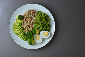 Salad bowl with quinoa and green vegetables - green peas, avocado, broccoli and eggs. Healthy food, green salad palte.