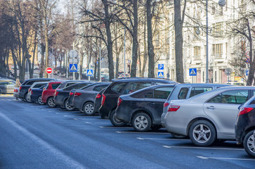 Cars parked on street in european city in sunny winter day. Background