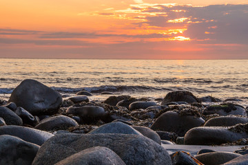 sunset on Unstad beach surrounded by mountains in Lofoten in Norway