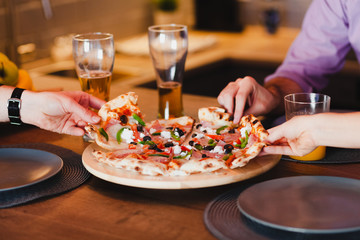 Friends eating pizza at the table