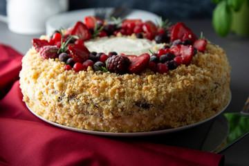 Homemade sponge cake with cream and fresh berries. Carrot and orange cake, decorated with berry. sweet dessert. Whole deliciouse cake. Gray background.