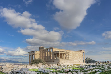 View of the Porch of the Caryatids and the Erechtheion temple on the Athens Acropolis with a view of Athens and a mountains Lycabettus Hill  and St Georges and a crowd of tourists in the background