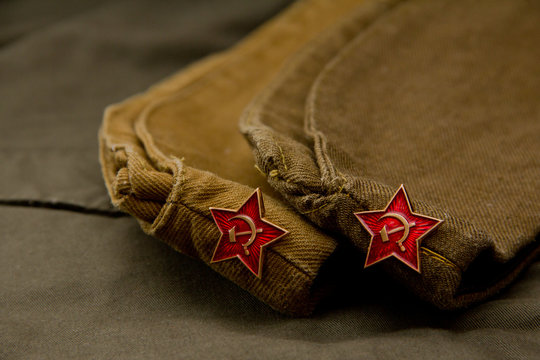 Two Soviet soldier caps in the background