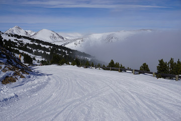 snowy slope in the Pyrénées on a sea of clouds on a sunny day