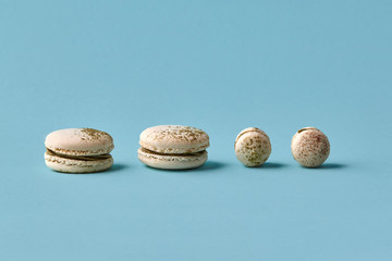 White macarons cake with colorful powder, top view, flat lay, sweet macaroon on blue background....