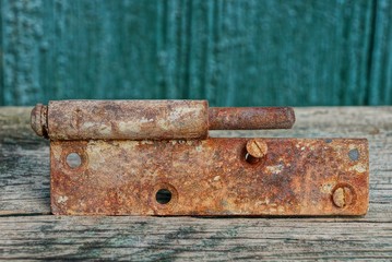 old rusty brown door hinge lies on a gray table