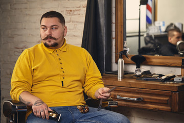 Stylish barber man with hairdressing tools in his hands prepare for work