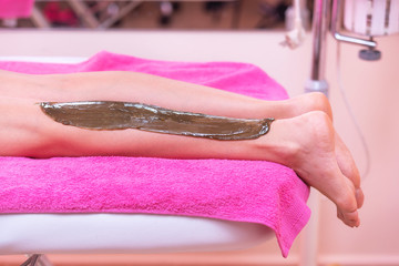 Beautician waxing woman legs, depilation in beauty Spa .