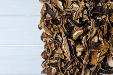 many dried mushrooms lies on a white wood desk
