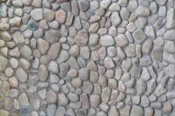 Brown stone wall of pebbles, background, texture