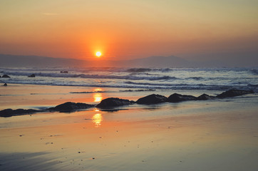 Fototapeta na wymiar Beautiful sunset with orange tones on Barrika beach, vizcaya, Basque Country, Spain