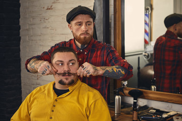 Client during beard shaving in barber shop