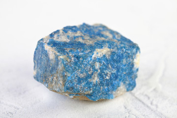 Natural mineral - rough Lazurite, Lapis Lazuli from Pamir, Tajikistan on white cement background.