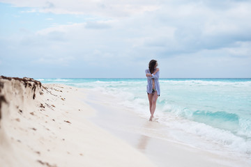 Female walking along sandy beach