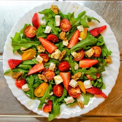 Fresh and healthy salad with fruits, vegetable, rocket and nuts
