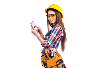 Beautiful girl builder holding a tablet. Clicks on the screen